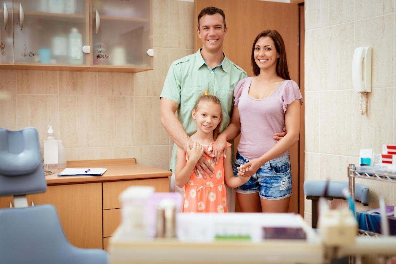 Happy young family standing together in a dental office, showcasing a welcoming environment for personalized dental care.